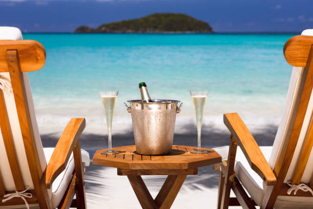 Bottle of champagne and two flutes on a luxury recliner set up at a tropical Caribbean beach